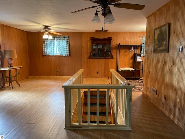 bar with wooden walls, ceiling fan, and dark hardwood / wood-style floors