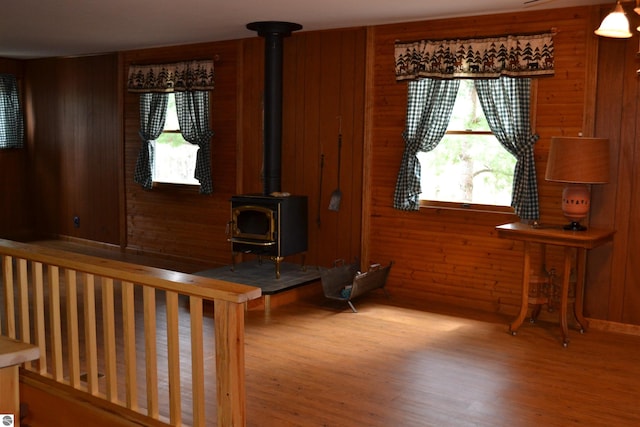 living room with light hardwood / wood-style flooring, a wood stove, and a healthy amount of sunlight