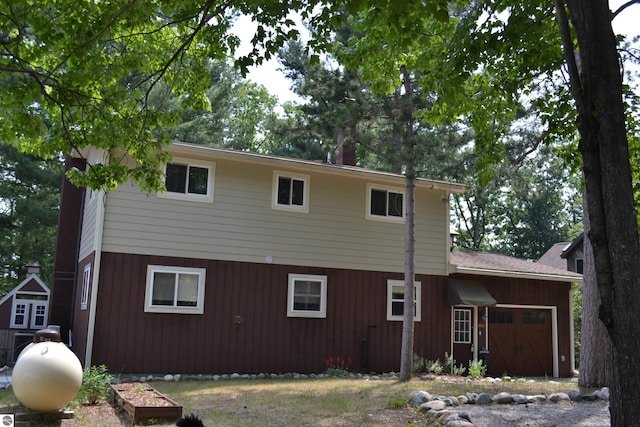 rear view of property with a garage