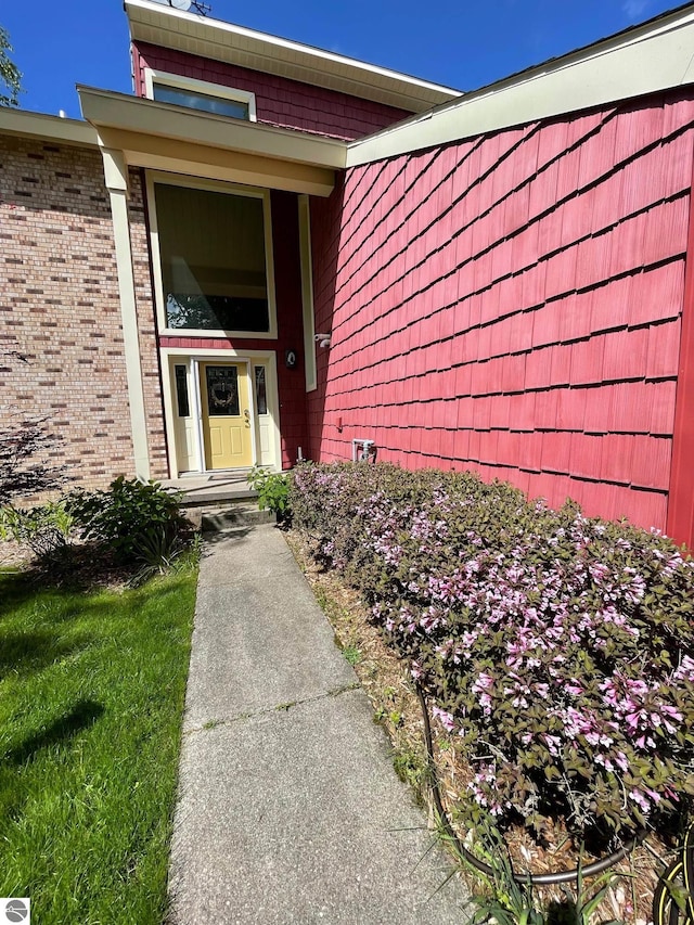 doorway to property featuring a lawn