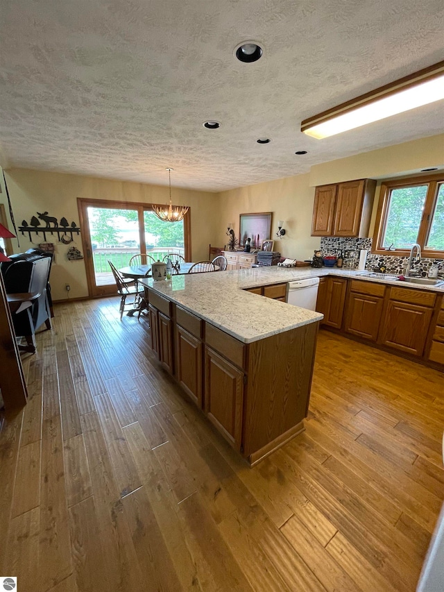 kitchen featuring light hardwood / wood-style flooring, hanging light fixtures, a chandelier, and a wealth of natural light