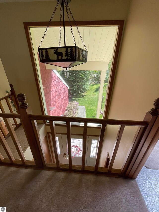 carpeted foyer featuring a notable chandelier