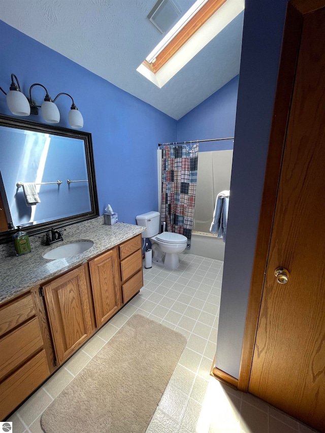 bathroom with tile floors, lofted ceiling with skylight, toilet, and vanity