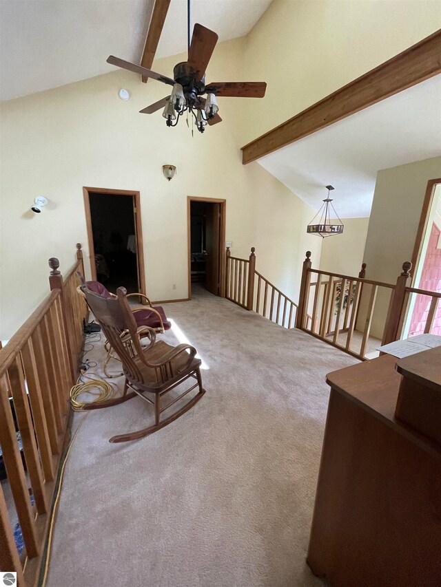 living area with ceiling fan, beam ceiling, light carpet, and high vaulted ceiling