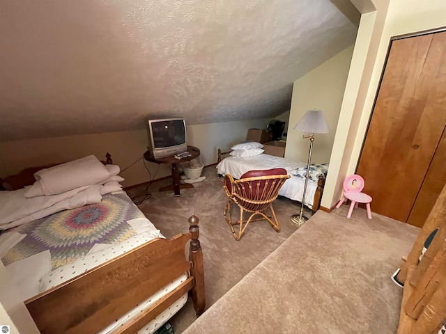 bedroom with vaulted ceiling, carpet flooring, a closet, and a textured ceiling