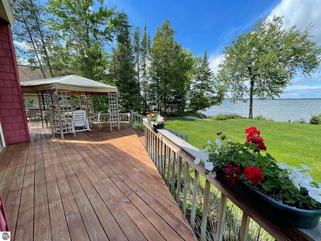 deck featuring a lawn and a water view