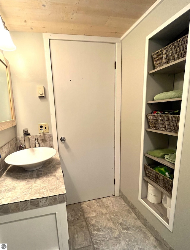 bathroom featuring tile flooring, wooden ceiling, and vanity