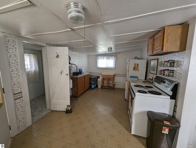 kitchen with light tile floors, white range with electric stovetop, and a wealth of natural light