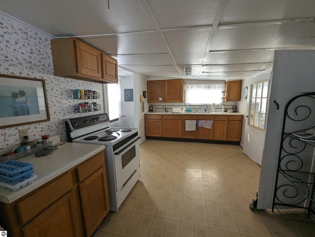 kitchen featuring light tile flooring, electric range, and sink