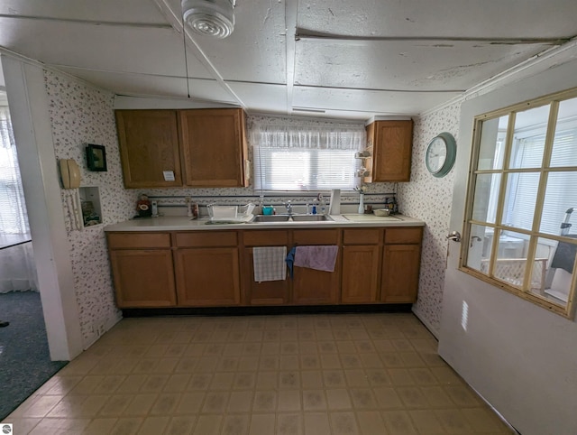 kitchen featuring sink, tasteful backsplash, and light tile floors