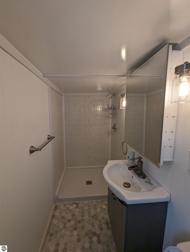 bathroom featuring tile floors, vanity, and tiled shower