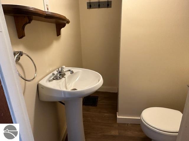 bathroom with toilet and wood-type flooring