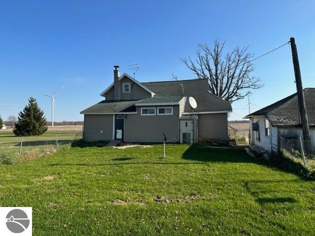 rear view of property with a lawn