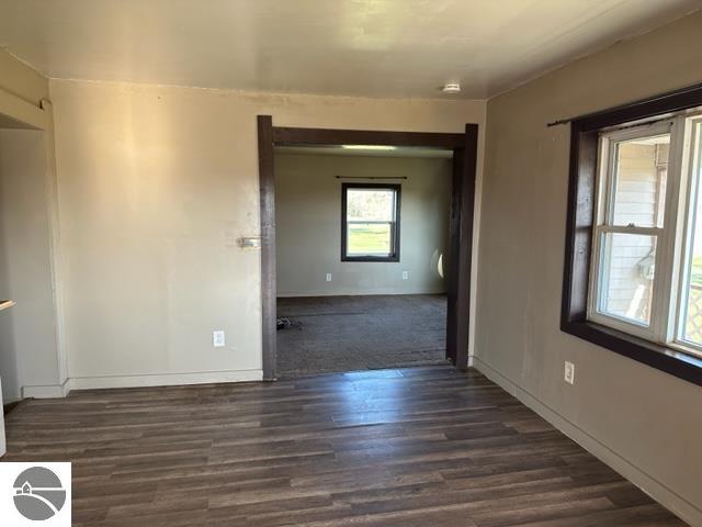 unfurnished room with dark wood-type flooring