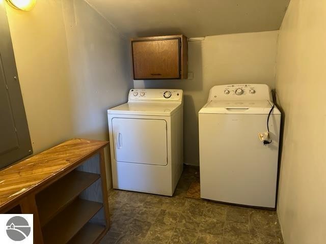 laundry area featuring cabinets, dark tile floors, and washer and dryer