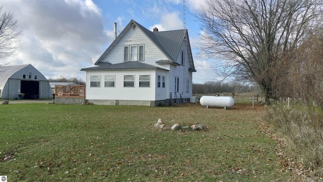 view of side of home with a wooden deck and a yard