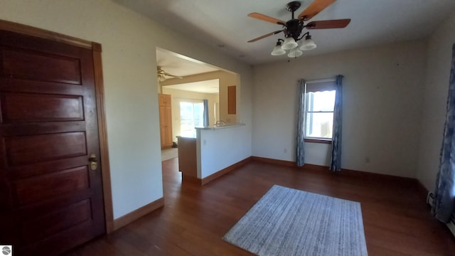 unfurnished room with a wealth of natural light, ceiling fan, and dark hardwood / wood-style flooring