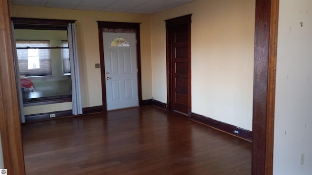 entryway with dark hardwood / wood-style flooring and a drop ceiling