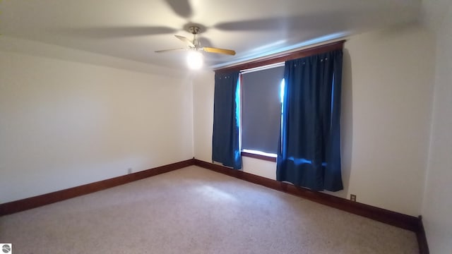 spare room featuring ceiling fan and carpet