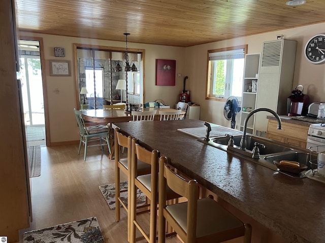 kitchen with pendant lighting, light wood-type flooring, sink, and wooden ceiling