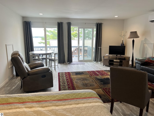 living room with a wall mounted AC and hardwood / wood-style floors