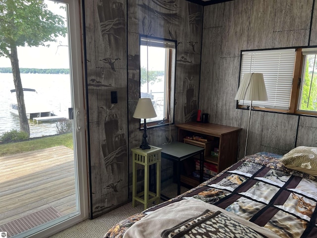 bedroom with wood walls and a water view