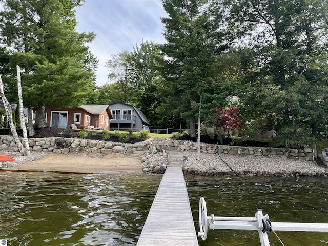 dock area with a water view and a balcony