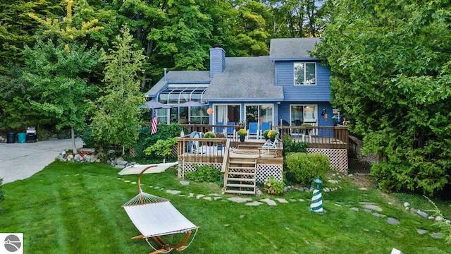 rear view of property with a wooden deck and a yard