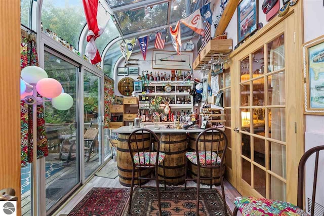 sunroom with vaulted ceiling, bar area, and a wealth of natural light