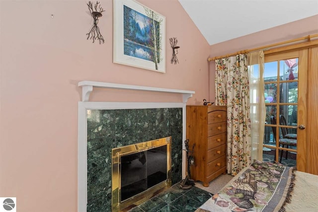 living room with dark carpet, a tile fireplace, and vaulted ceiling