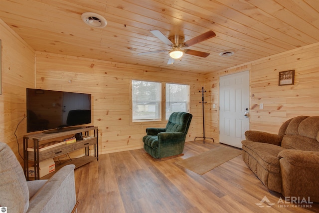 living room with ceiling fan, wood ceiling, wood-type flooring, and wood walls