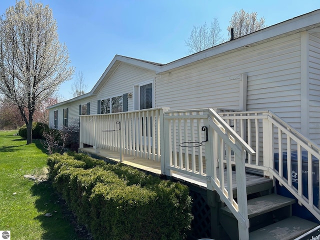 rear view of property featuring a lawn and a deck