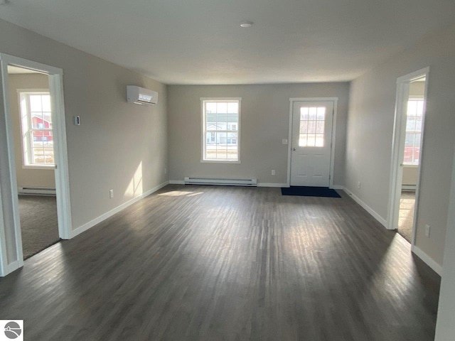 interior space with baseboard heating, dark hardwood / wood-style floors, and a wealth of natural light