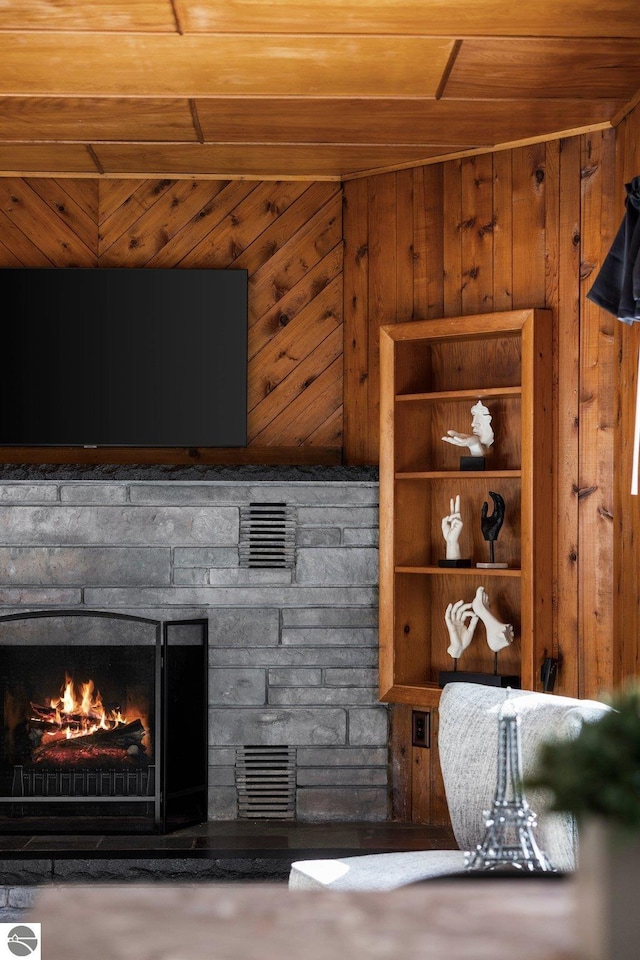 interior space featuring wooden ceiling, wooden walls, and a fireplace