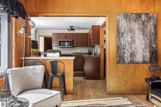 kitchen featuring tasteful backsplash, light hardwood / wood-style flooring, and sink