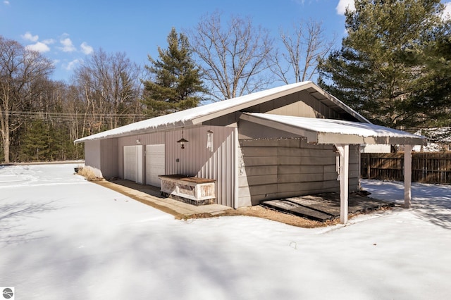 view of snowy exterior with a garage