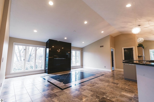 entryway featuring plenty of natural light, a chandelier, and vaulted ceiling