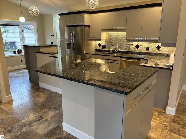 kitchen featuring gray cabinetry, a center island, hanging light fixtures, and appliances with stainless steel finishes