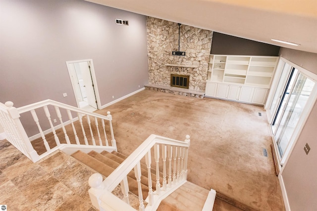 unfurnished living room with high vaulted ceiling and a stone fireplace