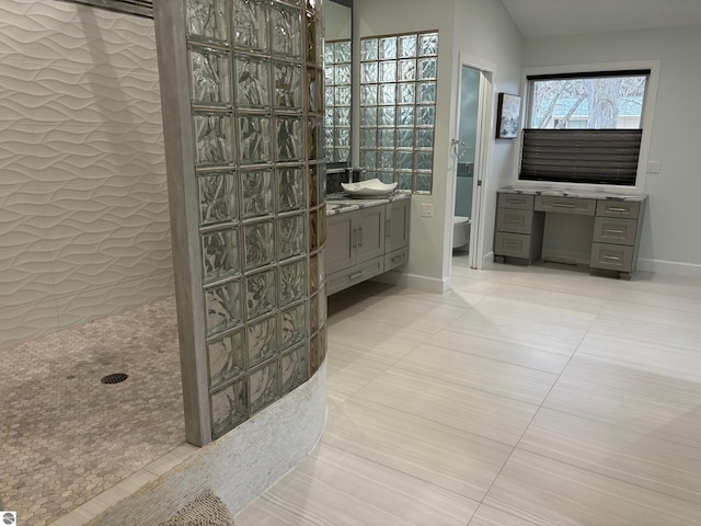 bathroom with vanity, lofted ceiling, tile patterned floors, toilet, and walk in shower