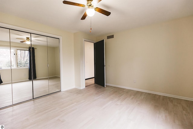 unfurnished bedroom featuring ceiling fan, light wood-type flooring, and a closet