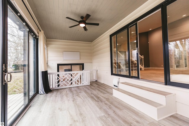 unfurnished sunroom with ceiling fan and wood ceiling