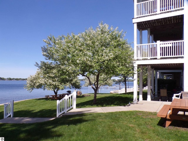 view of yard featuring a balcony, a patio, and a water view