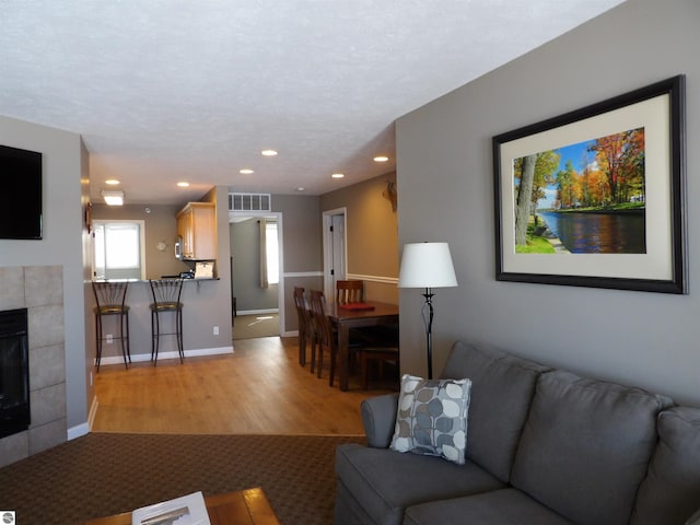 living room featuring light hardwood / wood-style flooring and a tile fireplace