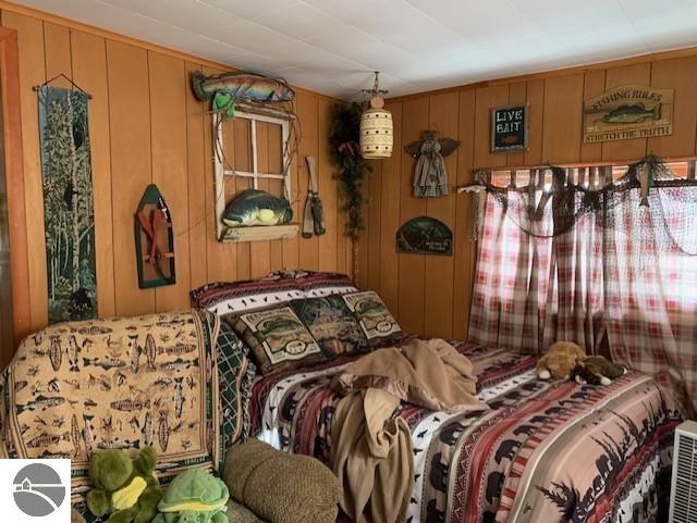 bedroom featuring wooden walls