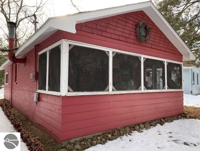 snow covered property with a sunroom