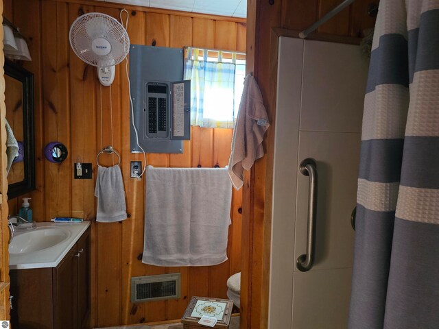 5934 Chippewa Trl, Hale, MI 48739 - full bath featuring wooden walls, visible vents, vanity, electric panel, and a shower with curtain