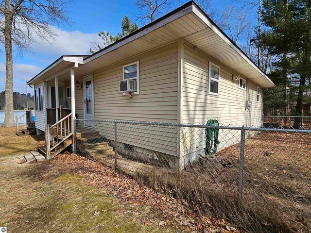 5934 Chippewa Trl, Hale, MI 48739 - view of side of home featuring a porch, cooling unit, crawl space, and fence