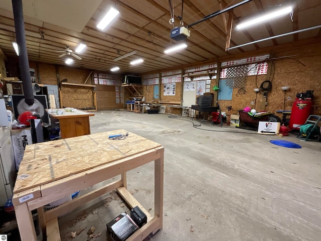 garage featuring a workshop area, a garage door opener, and ceiling fan