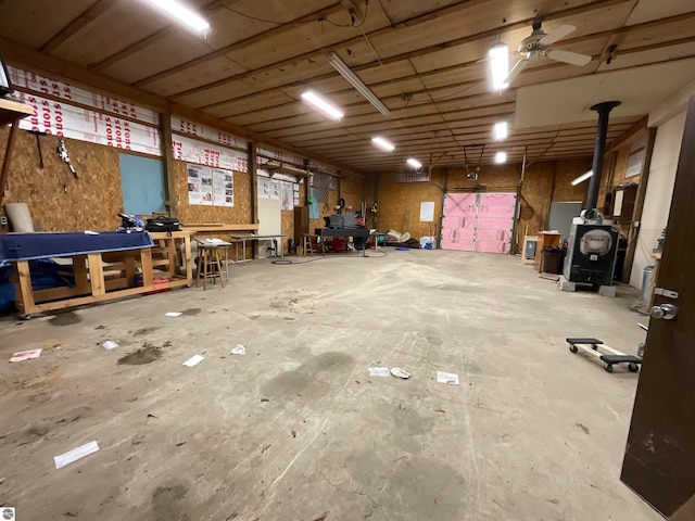 basement featuring a wood stove and ceiling fan